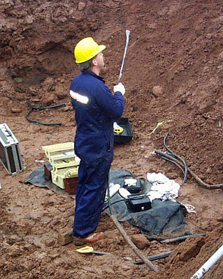 An MTT employee holds the cut fibre-optic cable